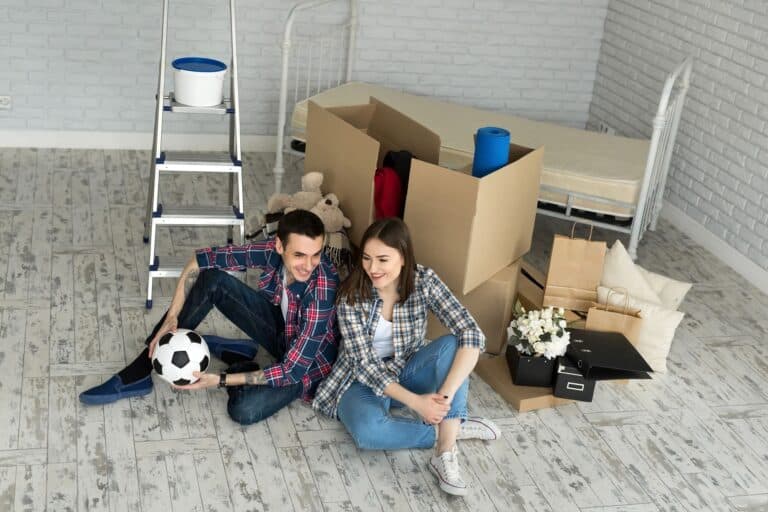 A young couple in their new home with cardboard boxes to unpack