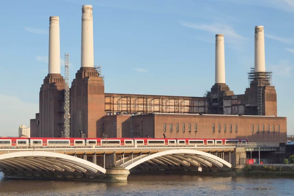 Battersea Power station with a passing train in the concept of 'how to use Battersea's public transport'.